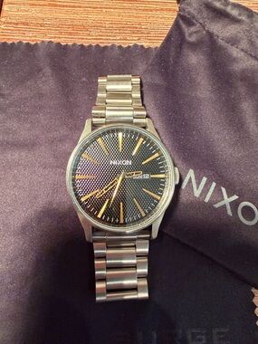 Nixon Men's Black Dial Watch with Gold Markers and Silver Bracelet